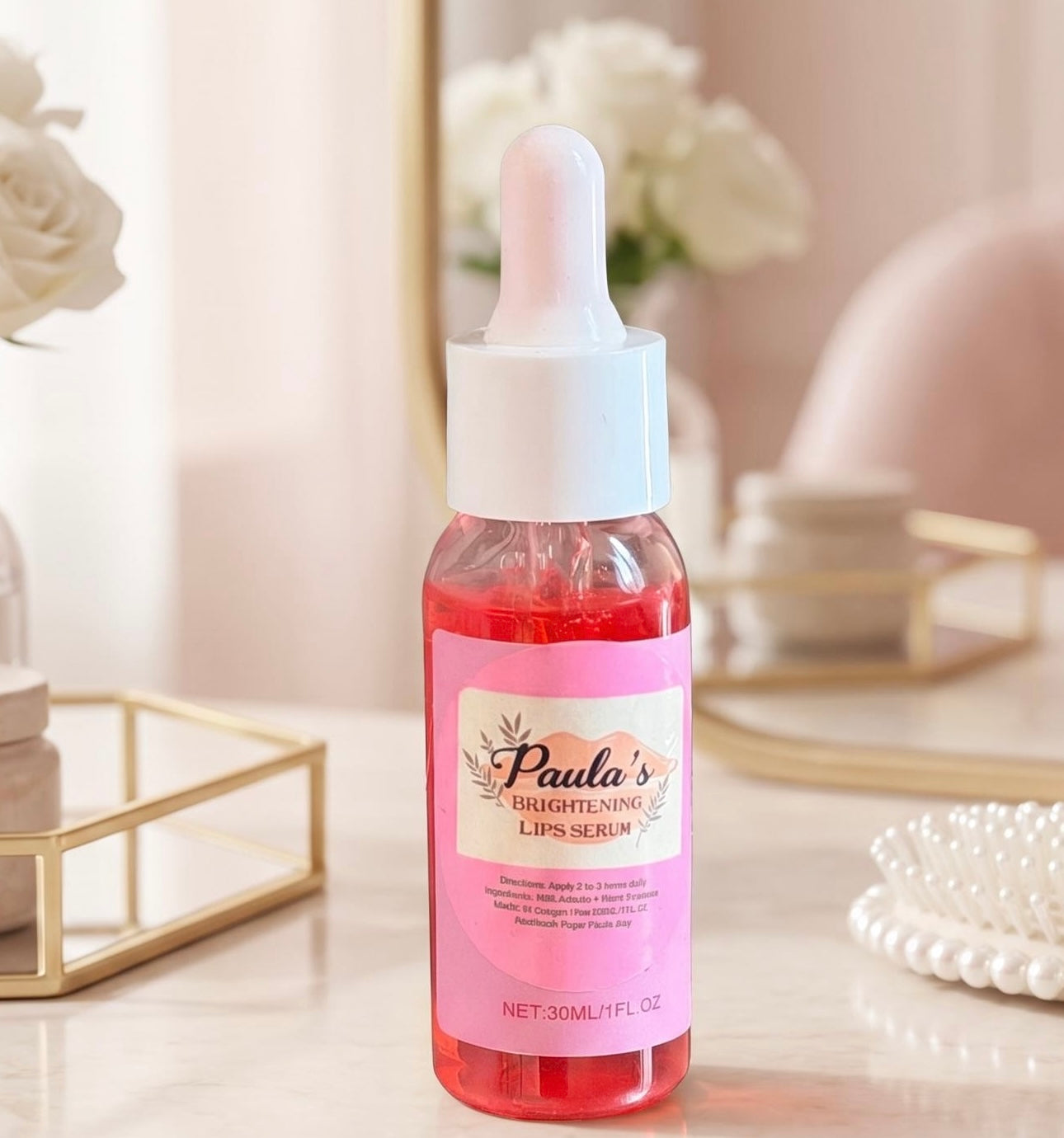 A bottle of Paula's Brightening Lips Serum with a pink label and white dropper cap, set on a marble surface with soft-focus decorative props in the background.